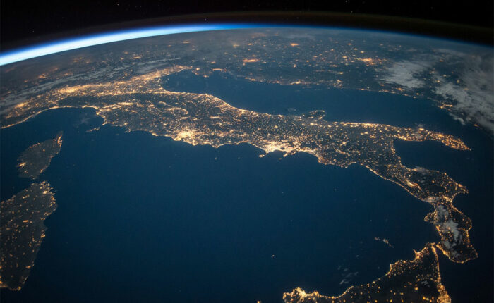 Satellitenbild der Erde bei Nacht mit beleuchteten Städten.