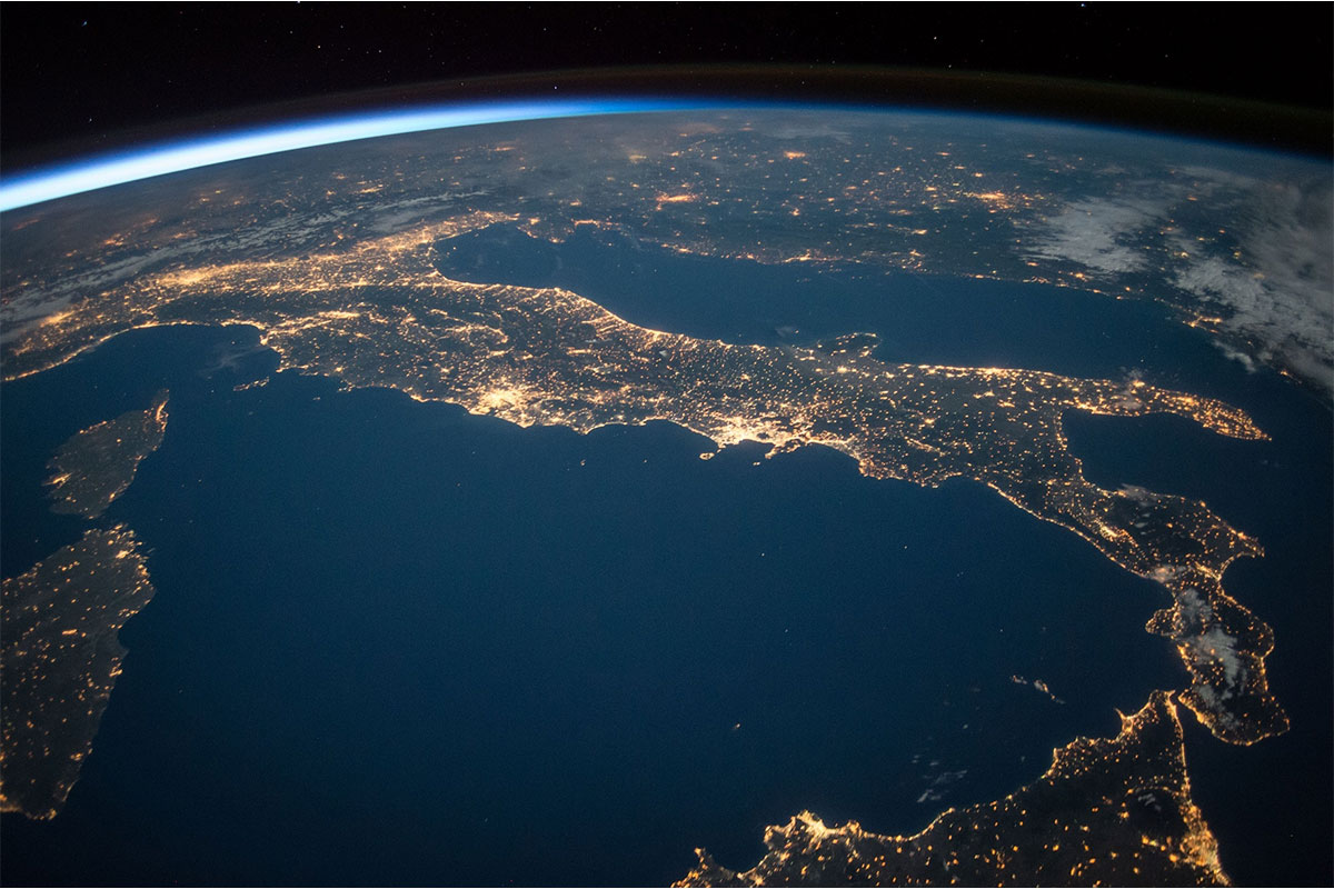 Satellitenbild der Erde bei Nacht mit beleuchteten Städten.